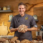 Marcel hält ein Brot in der Hand