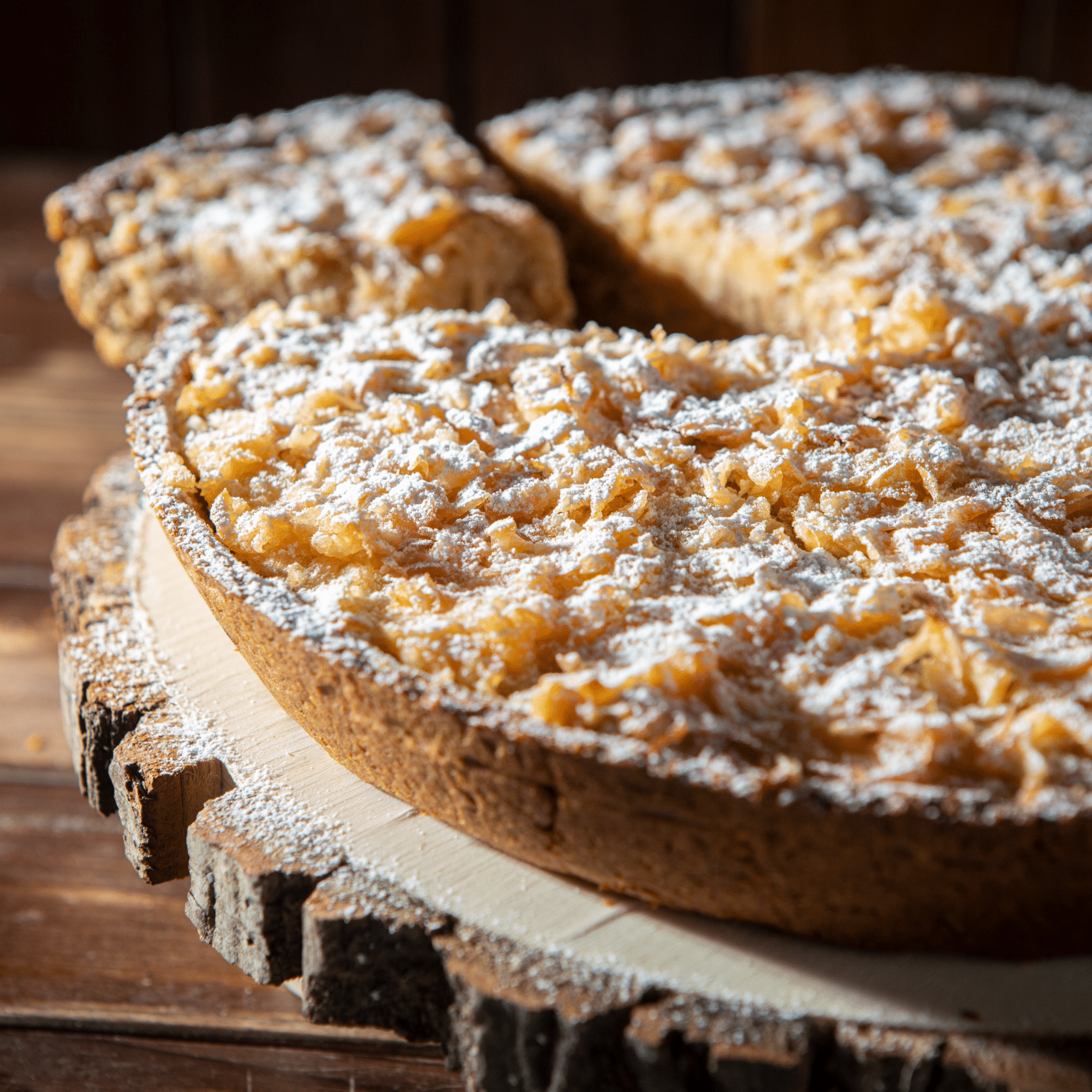 Apfelkuchen mit Puderzucker auf Holz