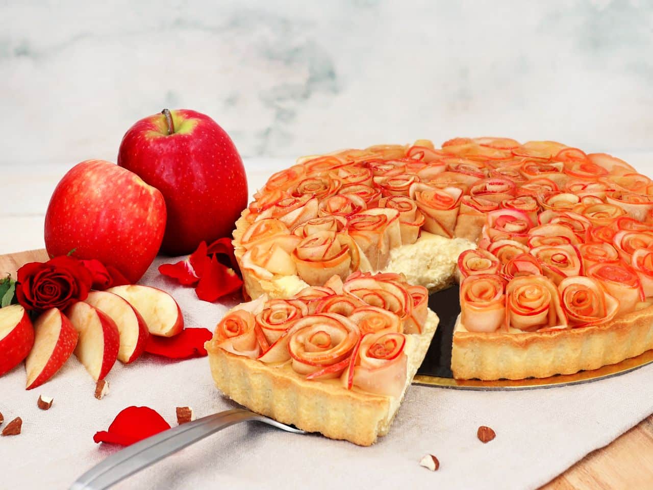 Apfeltarte mit Rosendekor und Äpfeln