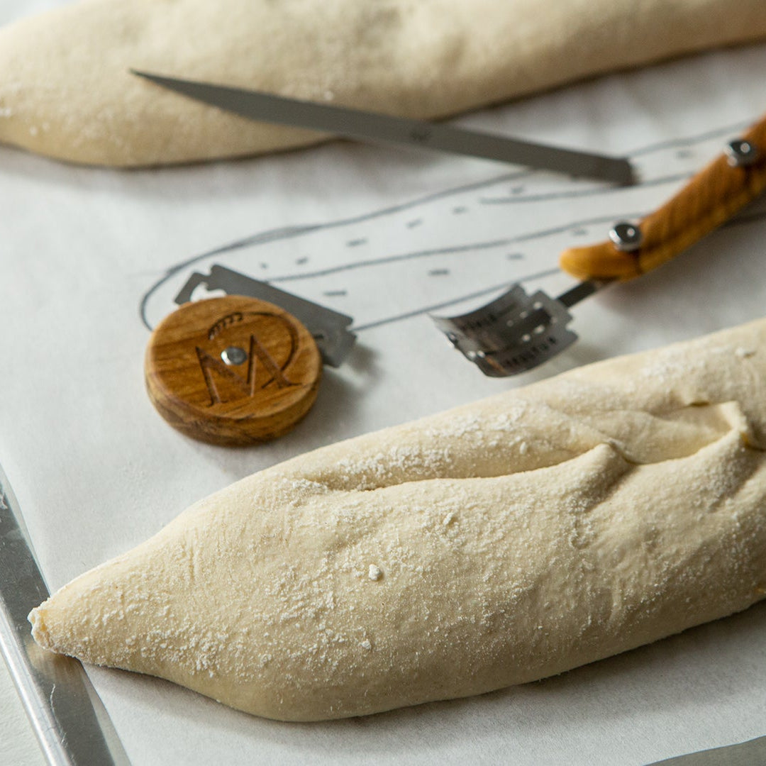 Baguette-Teig mit Bäckermesser eingeritzt