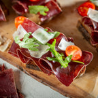 Bresaola-Brot mit Rucola, Tomaten