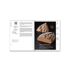 Aufgeschlagenes Brotbackbuch mit Roggenbrot