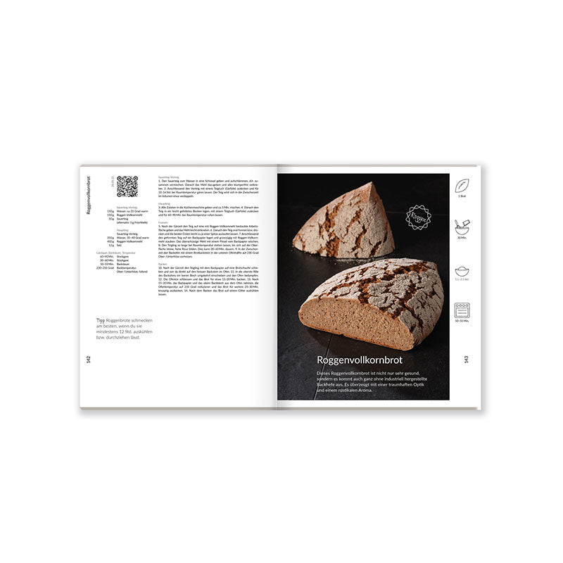 Aufgeschlagenes Brotbackbuch mit Roggenbrot