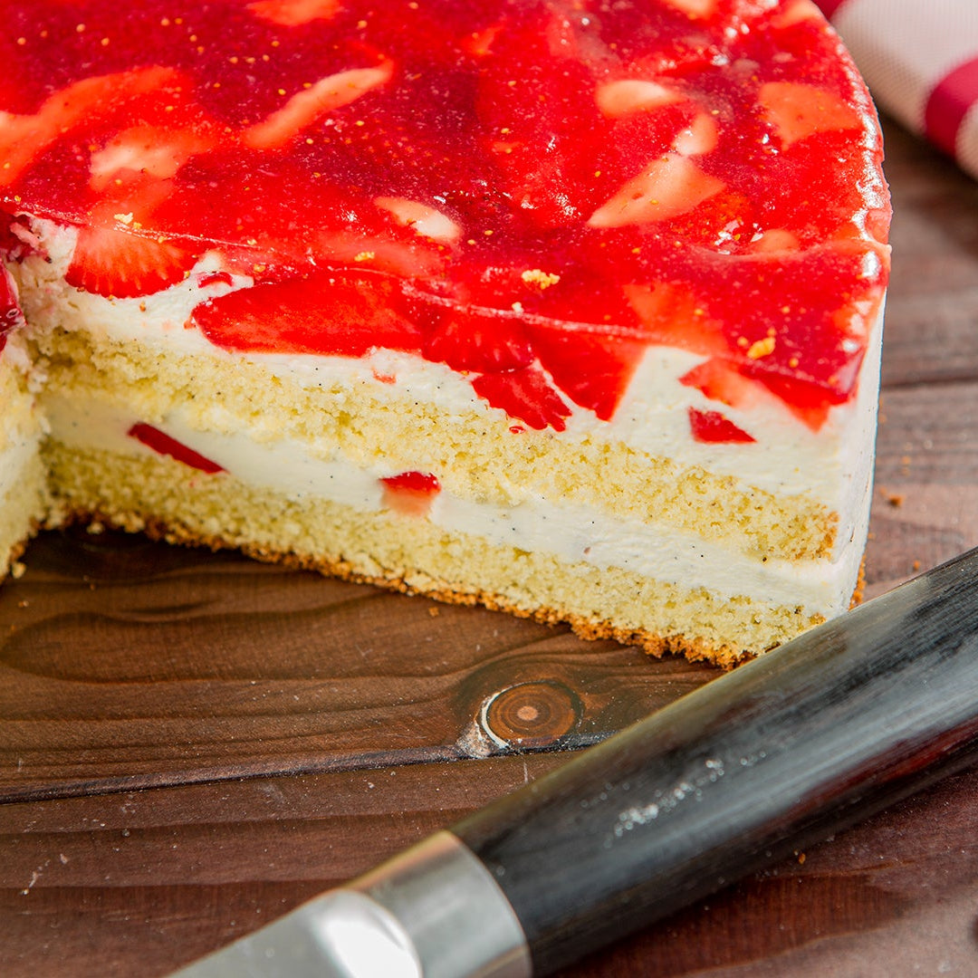 Erdbeerkuchen angeschnitten auf Holztisch