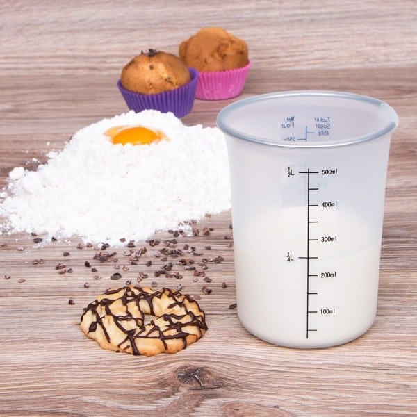 Messbecher mit Milch und Backzutaten