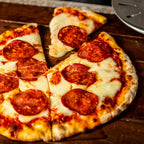 Frische Pizza Salami auf Holzbrett