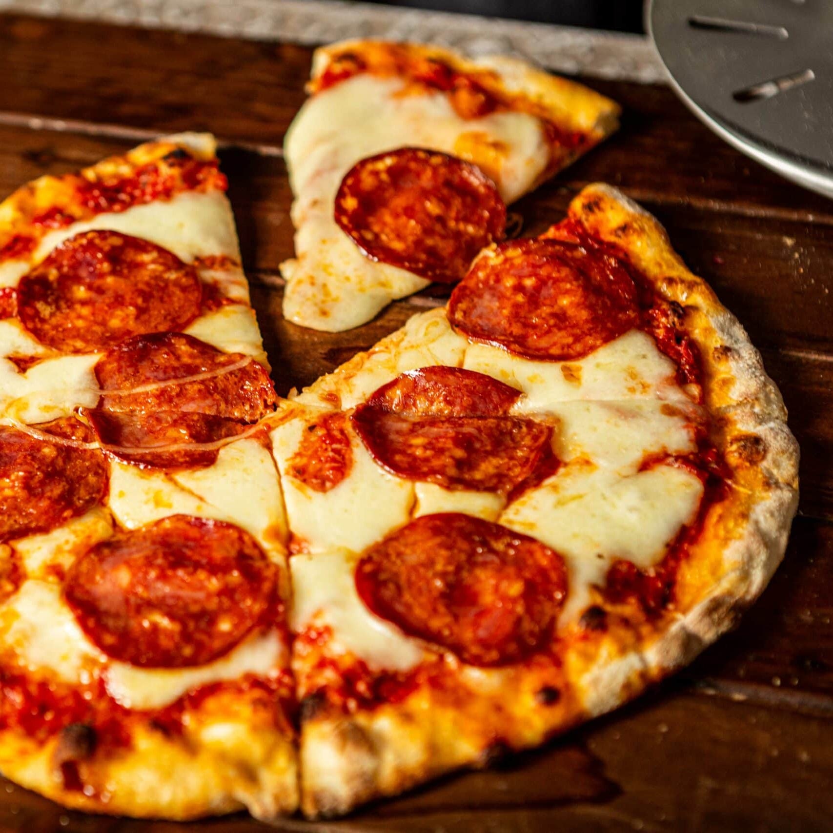 Frische Pizza Salami auf Holzbrett