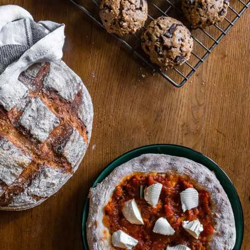 Brot, Pizza, Cookies auf Holztisch