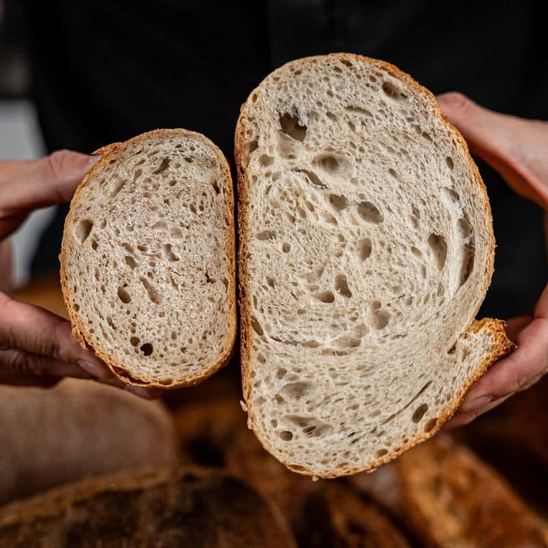 Aufgeschnittenes Sauerteigbrot in Händen