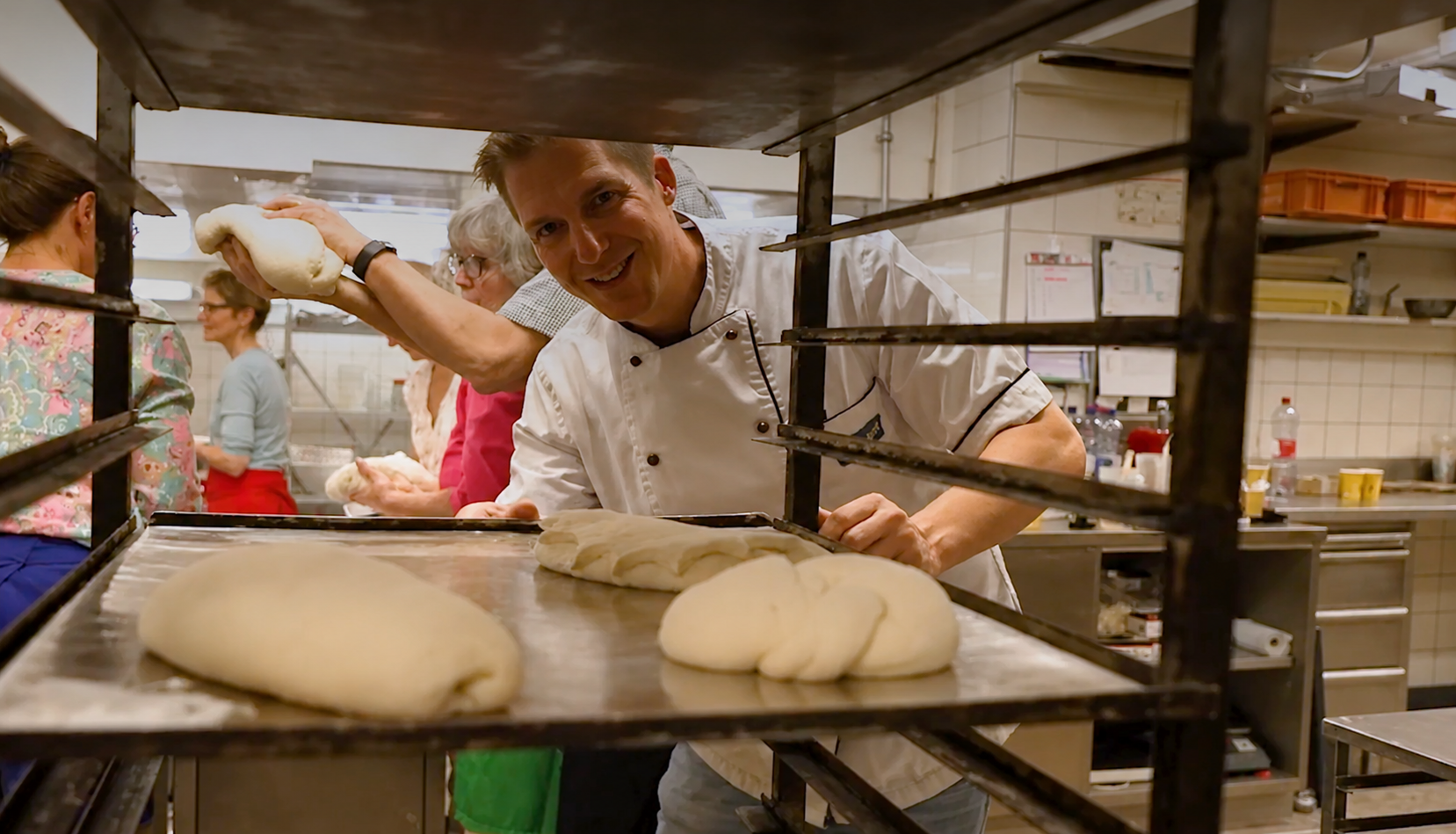 Bäcker formt Brotteig in Backstube